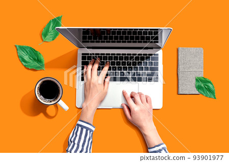 Person using a laptop computer with green leaves Person using a laptop computer with green leaves 93901977