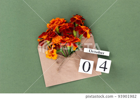 October 4. Bouquet of orange flower in craft envelope and calendar date on green background. Minimal concept Hello fall. Template for your design, greeting card October 4. Bouquet of orange flower in craft envelope and calendar date on green background. Minimal concept Hello fall. Template for your design, greeting card 93901982