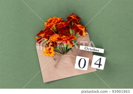 October 4. Bouquet of orange flower in craft envelope and calendar date on green background. Minimal concept Hello fall. Template for your design, greeting card October 4. Bouquet of orange flower in craft envelope and calendar date on green background. Minimal concept Hello fall. Template for your design, greeting card 93901983