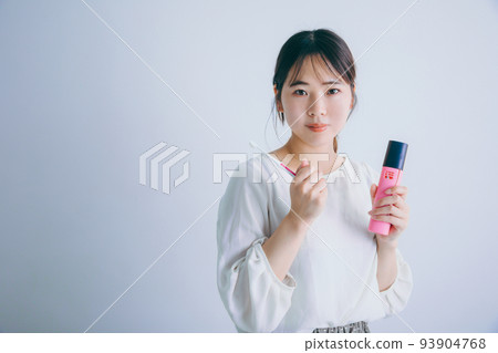 A woman holding a toothbrush and smiling toothbrush 93904768