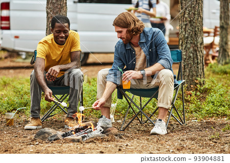 Men frying marshmallow on fire 93904881