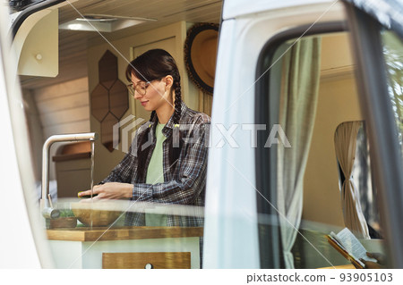 Woman washing vegetables in van 93905103