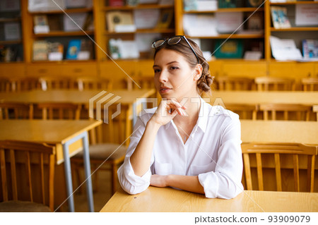 Young female student in white shirt in school class, youth education 93909079
