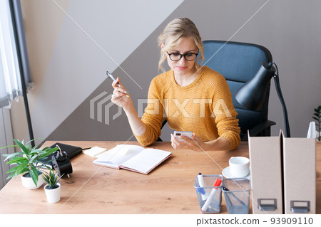 Caucasian business woman sits in office at table and writes padlocks Caucasian business woman sits in office at table and writes padlocks 93909110