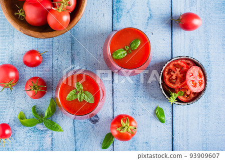 Fresh tomato juice with basil leaves in glasses on the table. Homemade organic drinks. Top view Fresh tomato juice with basil leaves in glasses on the table. Homemade organic drinks. Top view 93909607
