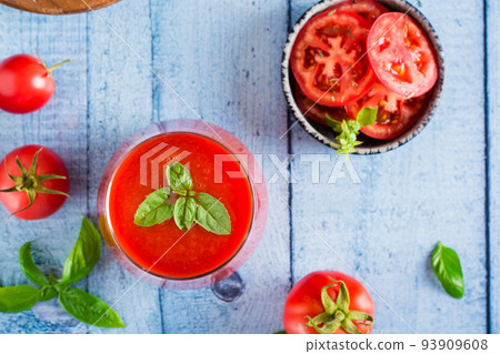 Fresh tomato juice with basil leaves in a glass. Homemade organic drinks. Top view. Closeup Fresh tomato juice with basil leaves in a glass. Homemade organic drinks. Top view. Closeup 93909608