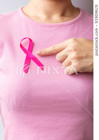 Pink October Breast Cancer Awareness month, woman hand hold pink Ribbon and wear shirt for support people life and illness. National cancer survivors month, Mother and World cancer day concept 93909628