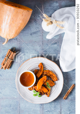 Baked pumpkin slices ready to eat and honey on a plate on the table. Vegetarian food. Thanksgiving Day. Top and vertical view 93910292