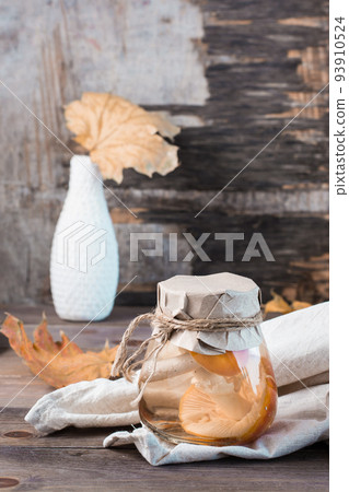 Pickled fly agarics in a jar on a wooden table. Microdosing and Alternative Medicine. Vertical view Pickled fly agarics in a jar on a wooden table. Microdosing and Alternative Medicine. Vertical view 93910524