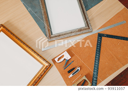 Framing Workshop. Stapler ruler and frames baguette handmade picture frame at studio table Framing Workshop. Stapler ruler and frames baguette handmade picture frame at studio table 93911037
