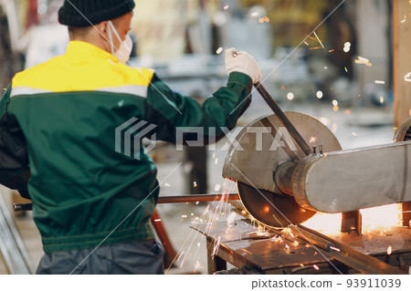 Metal processing with big compound mitre saw with circular blade. Sparks in metalworking at factory worker Metal processing with big compound mitre saw with circular blade. Sparks in metalworking at factory worker 93911039