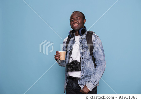 Happy young photography enthusiast with baggage and DSLR device going on vacation weekend trip. Professional photographer with camera and luggage ready for holiday urban citybreak. 93911363