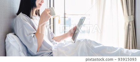 Image cut of a young woman checking SNS in the morning with a smartphone with coffee in one hand Image cut of a young woman checking SNS in the morning with a smartphone with coffee in one hand 93915093