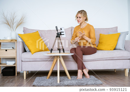 Caucasian woman blogger with notepad and talking camera live video recording Caucasian woman blogger with notepad and talking camera live video recording 93915121