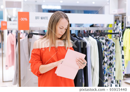 Shopping woman. Happy woman with handbag enjoying shopping in red dress. 93915440