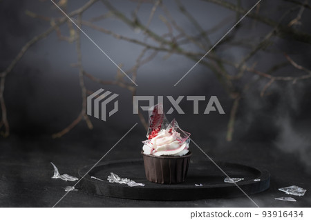 Halloween cupcake with buttercream, artificial glass and blood. Halloween muffin. Halloween creative food. 93916434