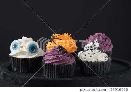 Halloween cupcakes with buttercream and holiday decoration. Halloween muffin. Halloween creative food. Halloween cupcakes with buttercream and holiday decoration. Halloween muffin. Halloween creative food. 93916436