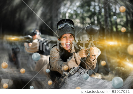Happy girl targeting shooting with paintball marker Happy girl targeting shooting with paintball marker 93917021