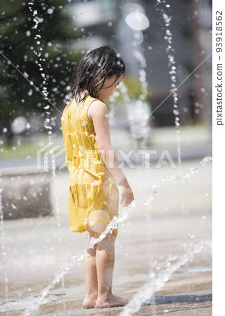 一個女孩在車站前廣場的噴泉里洗澡玩耍 93918562