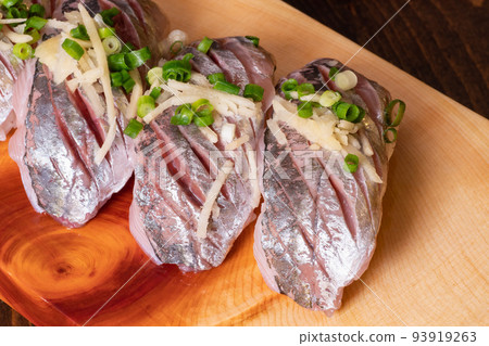 Fresh mackerel nigiri sushi. Topped with green onions and ginger condiments. Fresh mackerel nigiri sushi. Topped with green onions and ginger condiments. 93919263