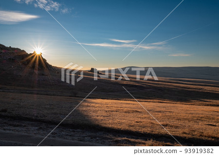 Morning sun rising from grasslands and rocky mountains in early winter in Mongolia Morning sun rising from grasslands and rocky mountains in early winter in Mongolia 93919382