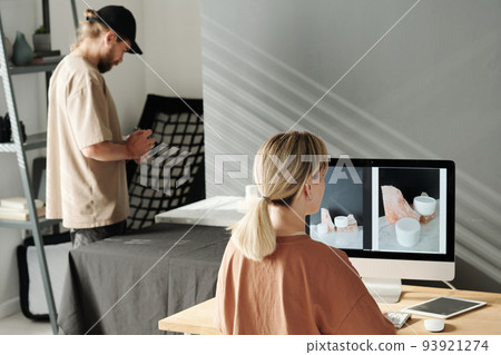 Back view of young creative photographer looking through new images Back view of young creative photographer looking through new images 93921274