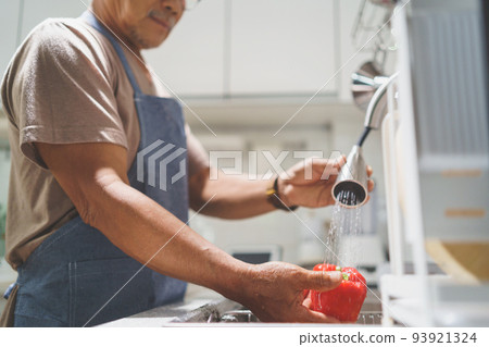 Asian senior man preparing washing bell pepper 93921324