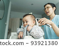 Chinese Mom cutting hair of child with hair clipper 93921380