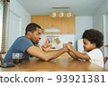 African father and son arm wrestling 93921381