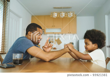 African father and son arm wrestling 93921381