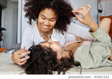 Happy young African American woman bending over her girlfriend 93921522