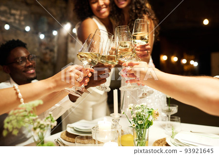 Hands of wedding guests and two intercultural brides clinking with flutes Hands of wedding guests and two intercultural brides clinking with flutes 93921645