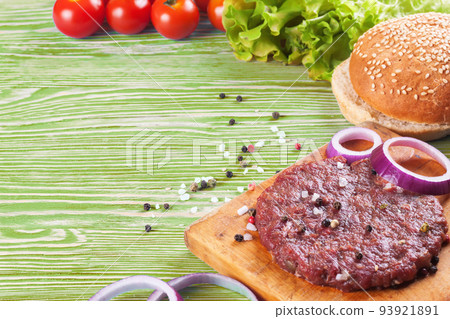 The ingredients for the burger on green wooden background The ingredients for the burger on green wooden background 93921891