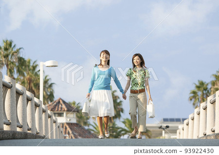 Mother girl walking hand in hand 93922430