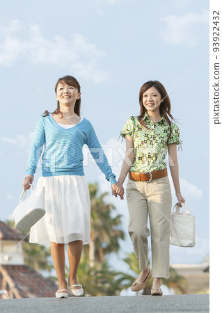 Mother girl walking hand in hand 93922432