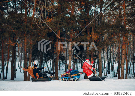 Santa claus riding snowmobile couple in love in the winter forest. 93922462