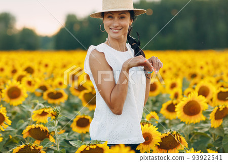 Beautiful young woman in a hat on a field of sunflowers Beautiful young woman in a hat on a field of sunflowers 93922541