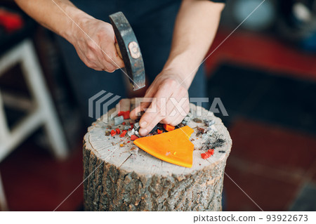 Craftsman cutting breaking smalt glass with hammer for mosaic artwork in workshop. Craftsman cutting breaking smalt glass with hammer for mosaic artwork in workshop. 93922673