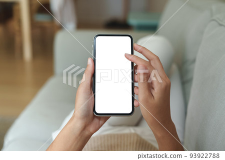 close-up hand using phone showing white screen in living room 93922788