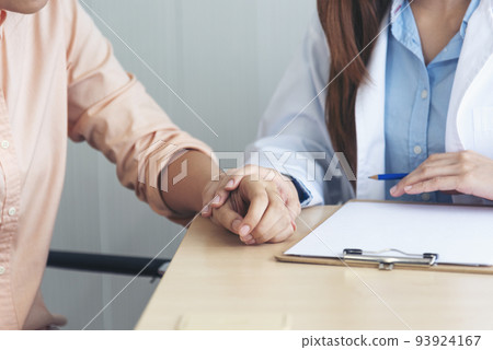Close up hands Woman doctor holding hands patient encourage cheer up consultation at hospital medicare clinic. Doctor talking to patient support giving hope mental health therapy consoling recovery Close up hands Woman doctor holding hands patient encourage cheer up consultation at hospital medicare clinic. Doctor talking to patient support giving hope mental health therapy consoling recovery 93924167