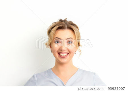 Portrait of a young caucasian happy woman doctor wearing blue workwear smiling against the white background Portrait of a young caucasian happy woman doctor wearing blue workwear smiling against the white background 93925007