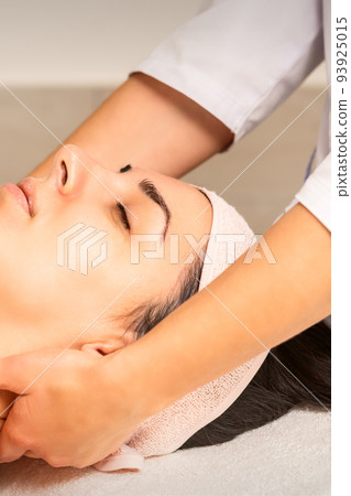 Facial massage. Young caucasian woman getting a massage on her neck in a beauty clinic Facial massage. Young caucasian woman getting a massage on her neck in a beauty clinic 93925015