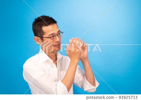 A man looking at the other person's expression while having a conversation on a string telephone A man looking at the other person's expression while having a conversation on a string telephone 93925713