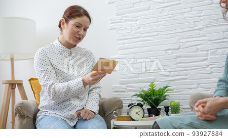 The psychologist uses metaphorical cards in a session with a patient. Caucasian woman tells associations.  93927884