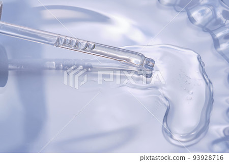 Dropper with serum or cosmetic oil on a blue background. 93928716