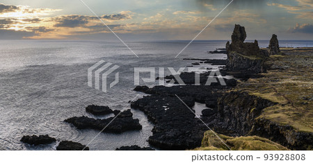 View during auto trip in West Iceland, Snaefellsnes peninsula, Snaefellsjokull National Park, Londrangar View Point. Spectacular black volcanic rocky ocean coast, landmark volcanic towers on cliff. 93928808