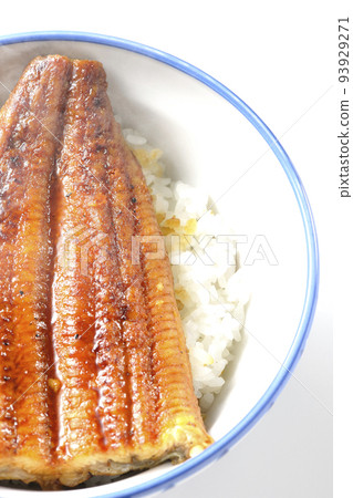 A bird's-eye view of a hot eel bowl with grilled eel on top of white rice against a white background 93929271