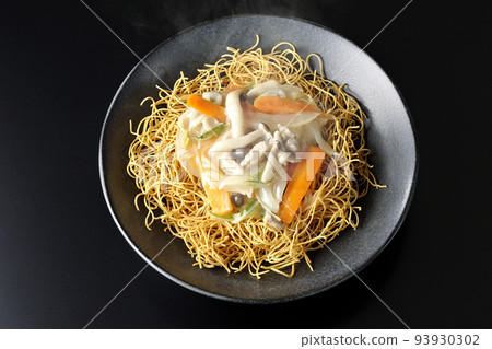 一張黑色背景的熱烏冬面，上面有豆瓣醬，裡面有石米吉蘑菇、胡蘿蔔、洋蔥等。 93930302