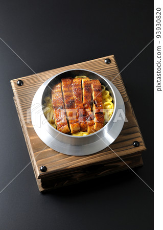 A bird's-eye view of a hot pot rice with grilled eel on a black background A bird's-eye view of a hot pot rice with grilled eel on a black background 93930820