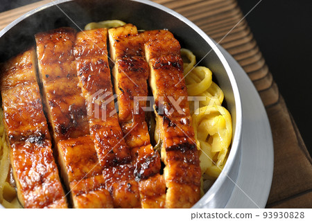 A bird's-eye view of a hot pot rice with grilled eel on a black background A bird's-eye view of a hot pot rice with grilled eel on a black background 93930828